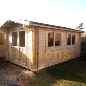 3m x 5m custom garden cabin with 0.5m roof canopy installed on concrete base in garden