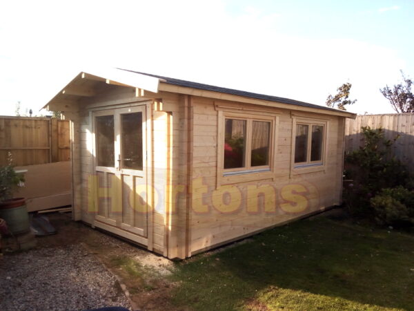 3m x 5m custom garden cabin with 0.5m roof canopy installed on concrete base in garden