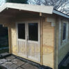 3m x 5m garden cabin front and glazed side wall in garden on slabbed base