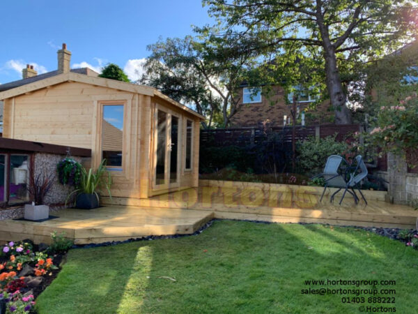 3.5x3.5m log cabin side on decking in garden